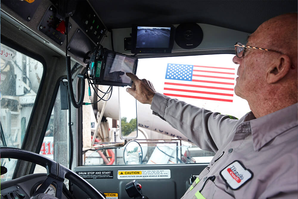 man in truck cab touching a touch screen tablet